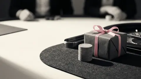 Ett inslaget paket bredvid en hög spelmarker på grön filt