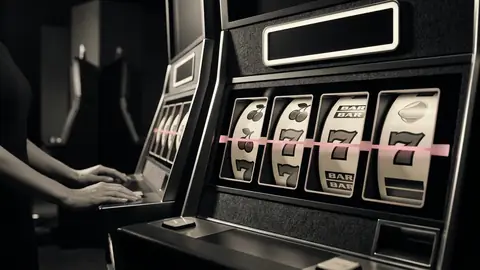 Upplysta spelautomathjul i en mörk casinomiljö med en lysande jackpottpanel ovanför